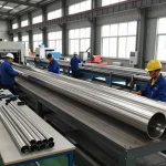 Sumwin stainless steel pipes being crafted in a busy industrial factory with skilled workers.